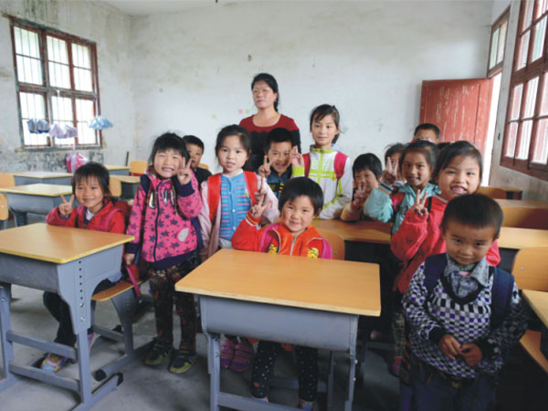 公司為一山村小學捐贈一批課桌椅，孩子們高興地和老師一起合影